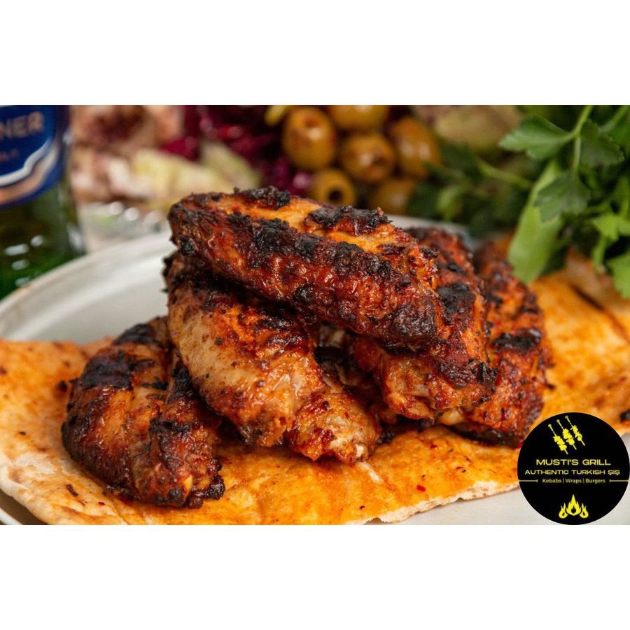 Flame-grilled chicken wings on flatbread at Musti's Grill & Bistro